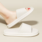White slide sandals worn by a person on a beige background