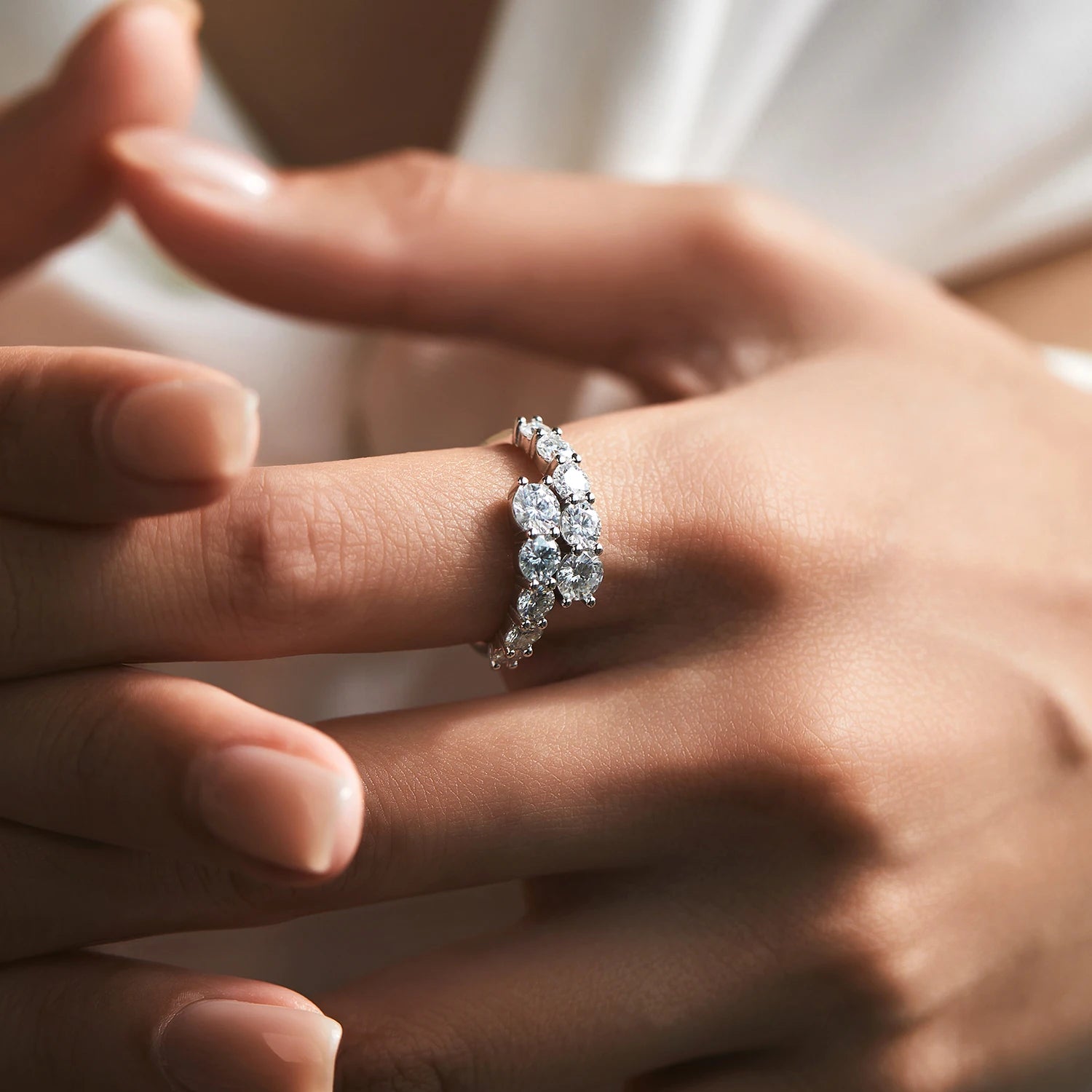 Close-up of a hand wearing a diamond ring with a blurred background