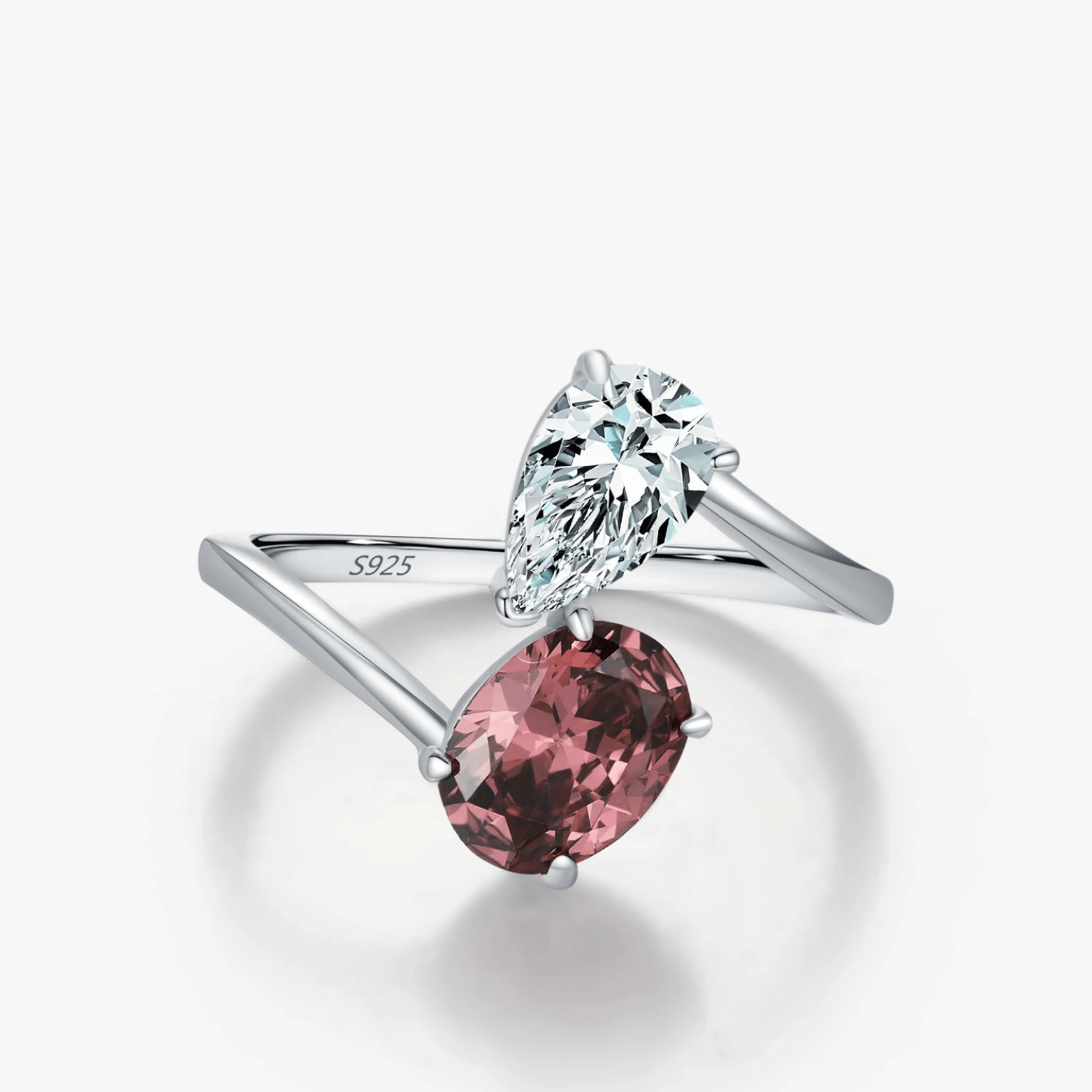 Silver ring with pink gemstone and clear gemstone on a white background